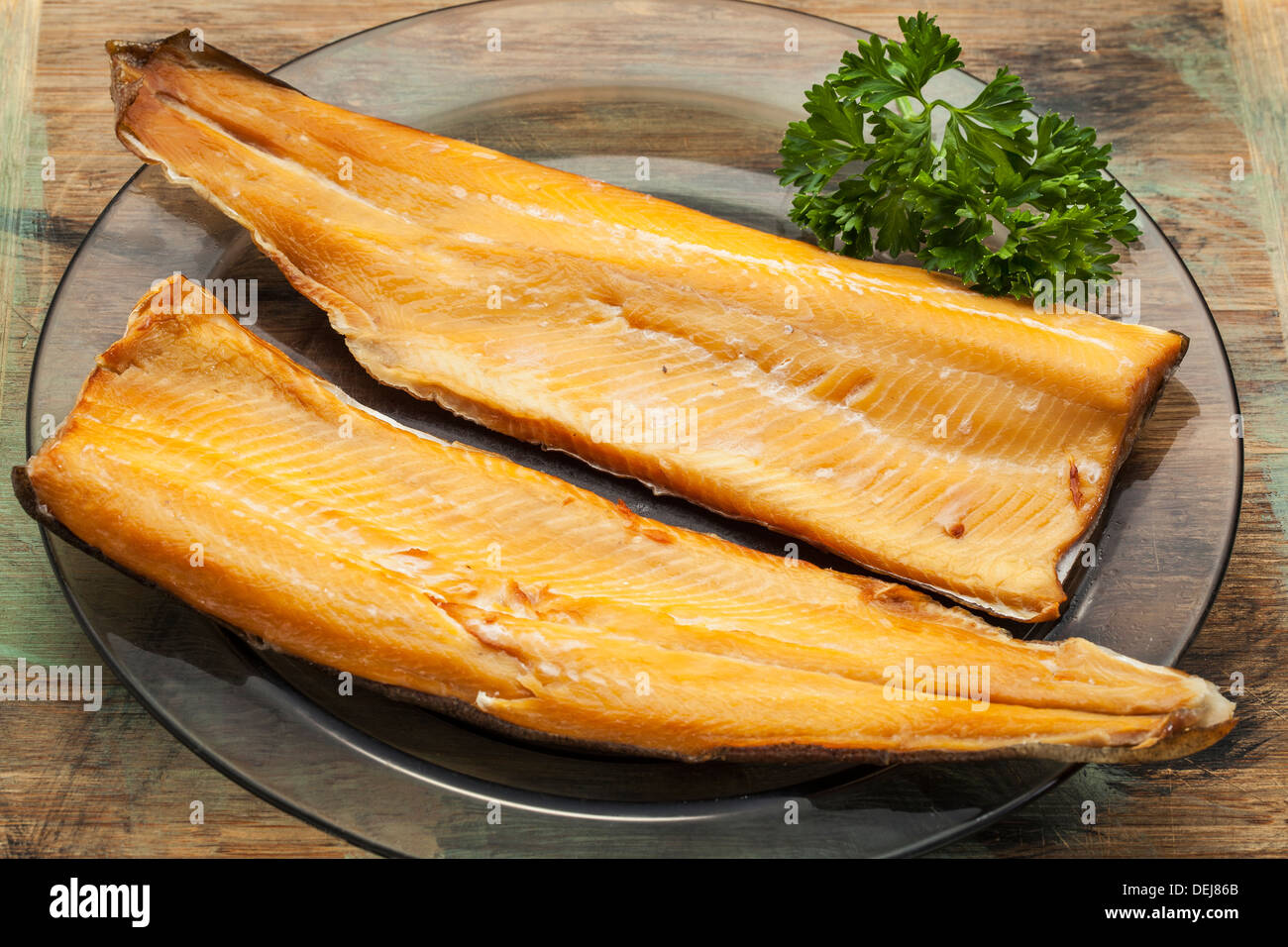smoked trout fillet on a glass plate with parsley leaf Stock Photo