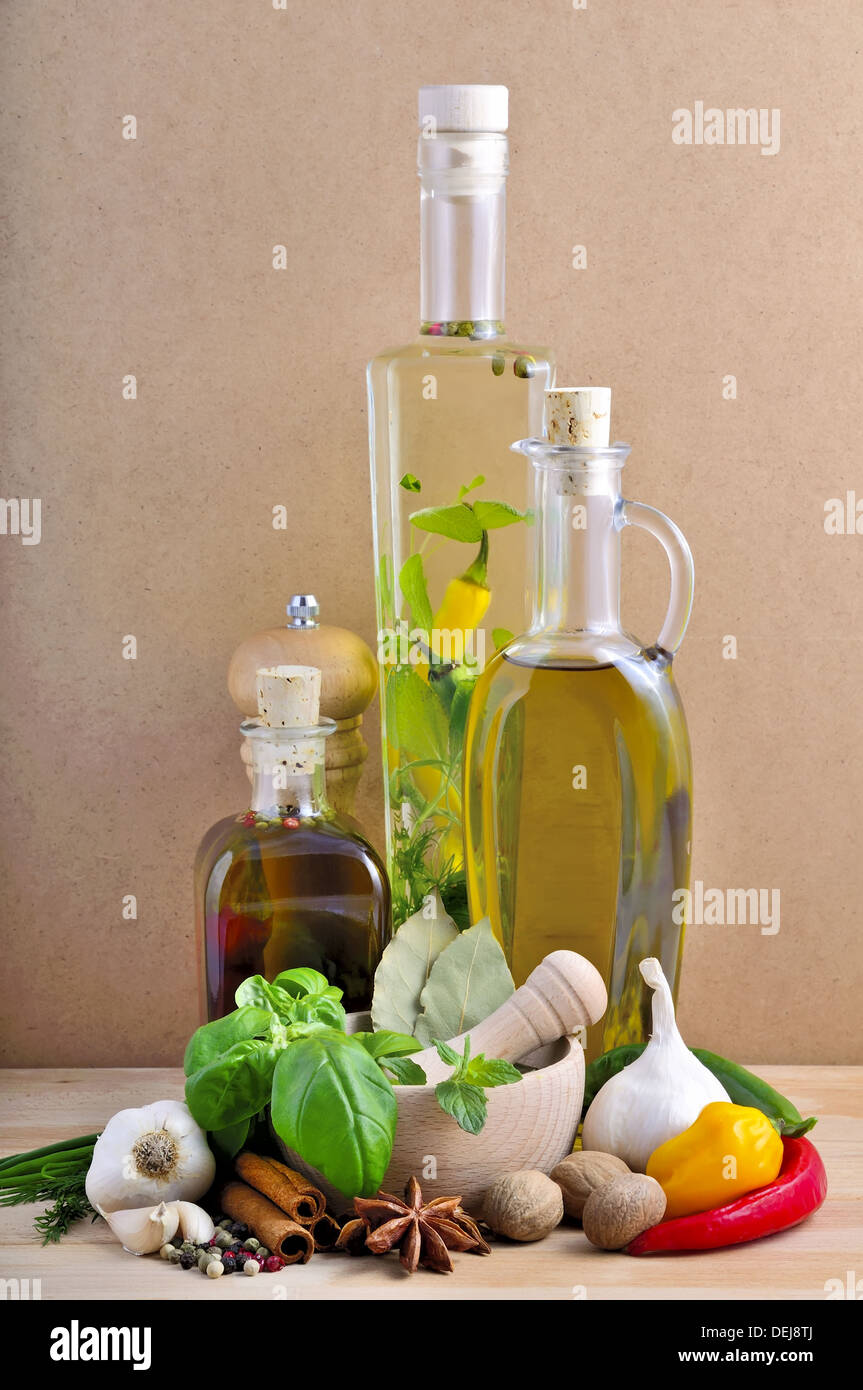 still life with infused olive oil, herbs and spices on a wooden background Stock Photo