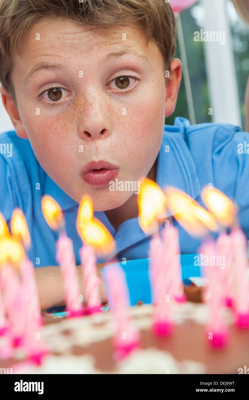 Happy male boy child blowing out birthday cake candles Stock Photo - Alamy
