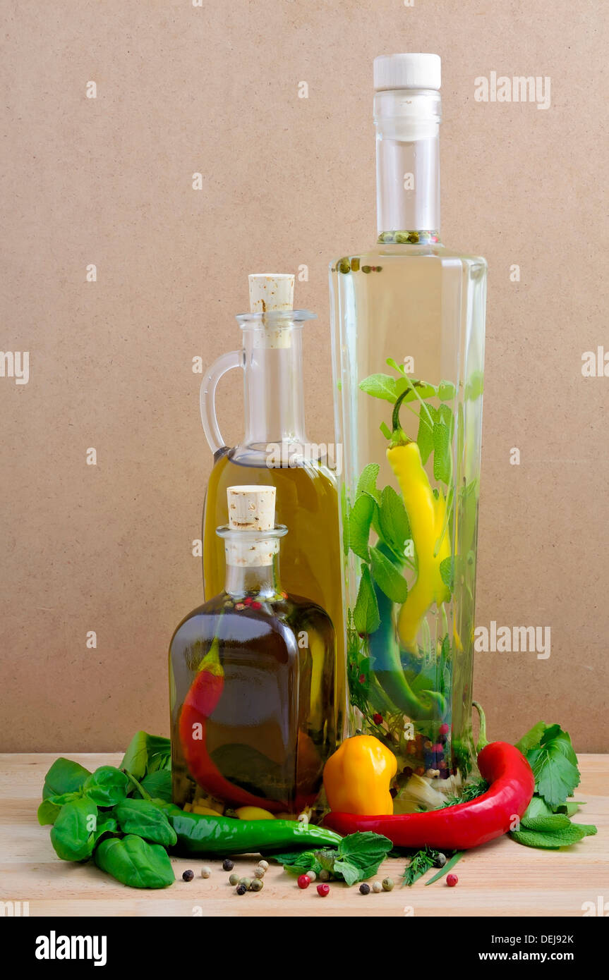 infused olive oil and herbs and ingredients on a wooden background Stock Photo