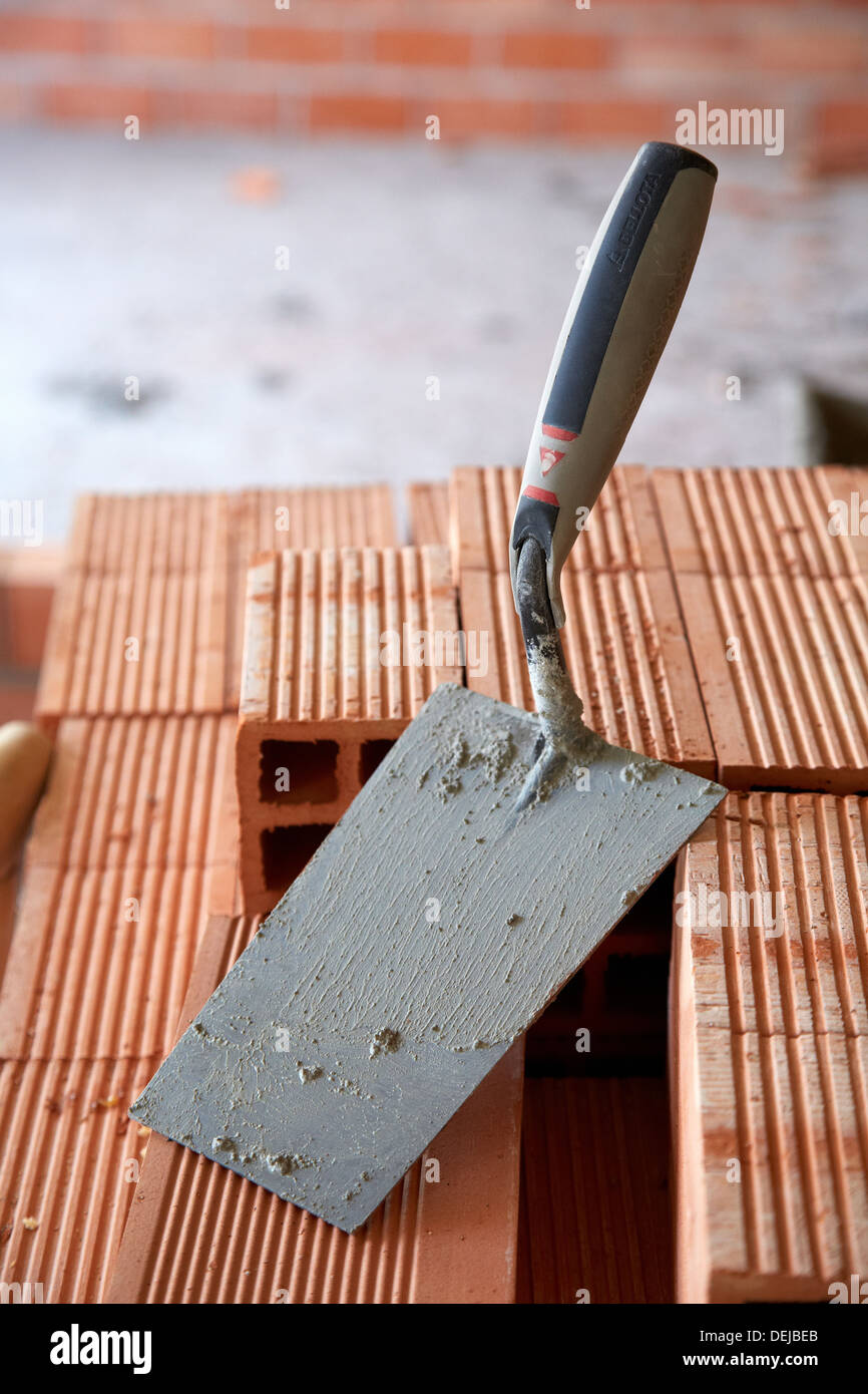 Construction worker with trowel, hand tools, Placement of brick with