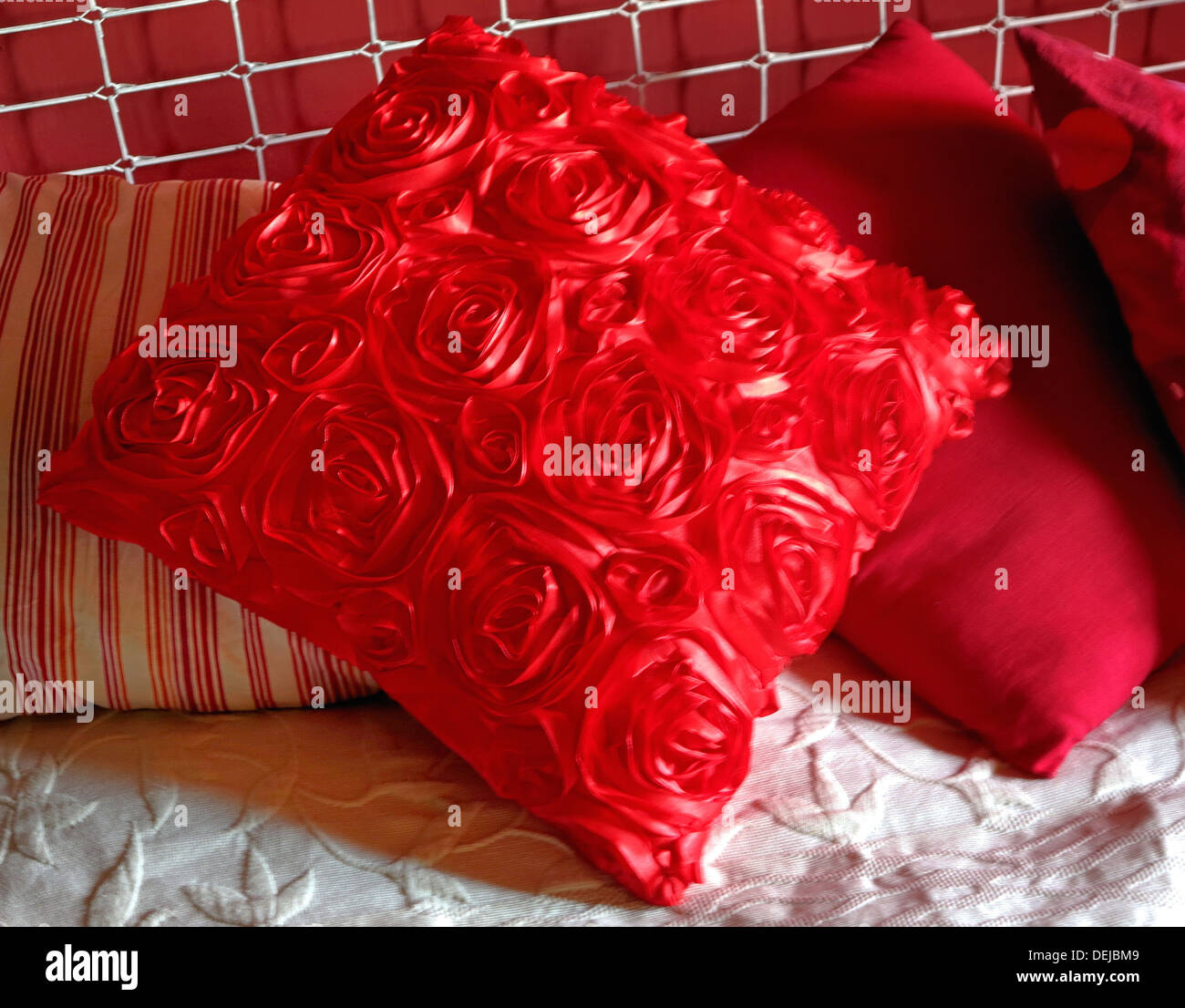 Red pillows in the bed and silver headboard Stock Photo