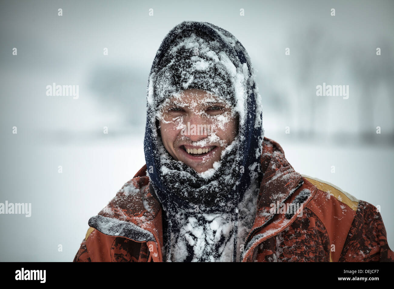Happy man covered by snow enjoying winter. Stock Photo