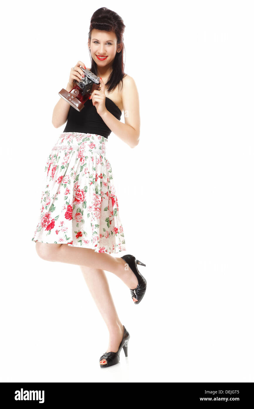 Full length pretty retro summer girl taking picture using vintage camera white background Stock Photo