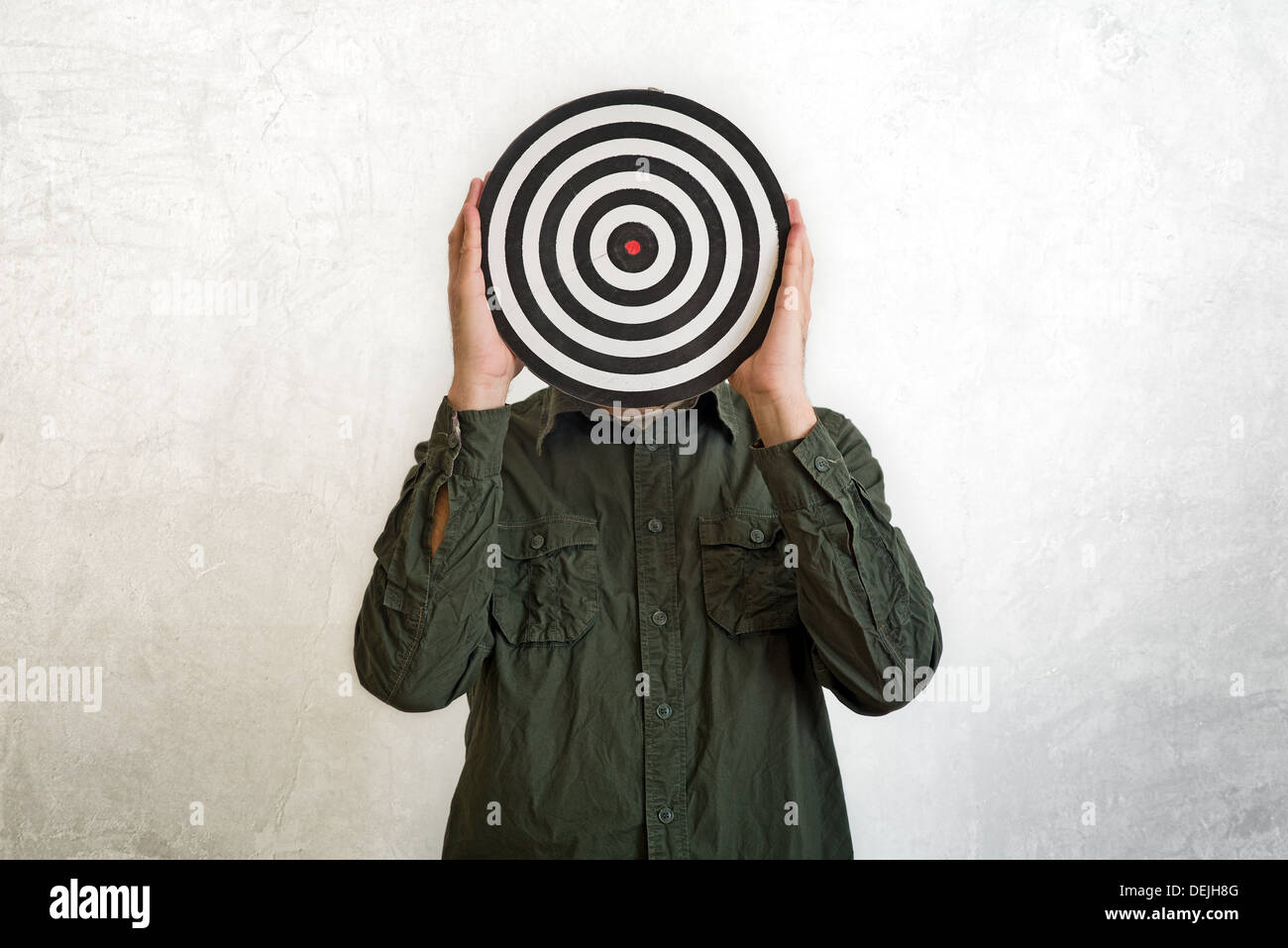 Man holding dartboard in place of head. Stock Photo
