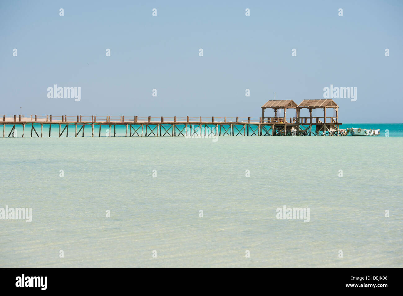 Long wooden jetty on a tropical island stretching out into the sea ...