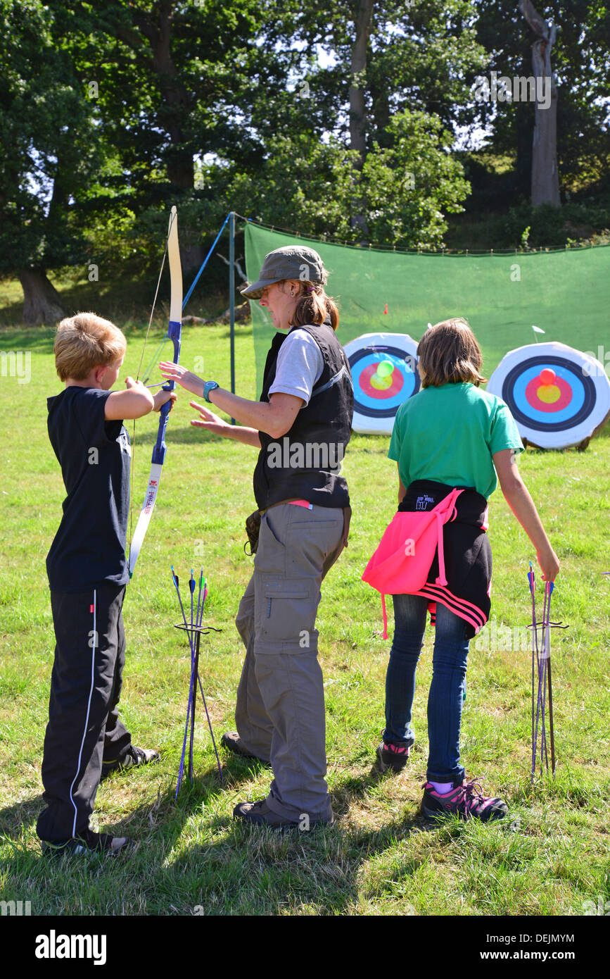 Children trying archery at The Dunster Agricultural Show, Dunster Castle Lawns, Dunster, Somerset, England, United Kingdom Stock Photo