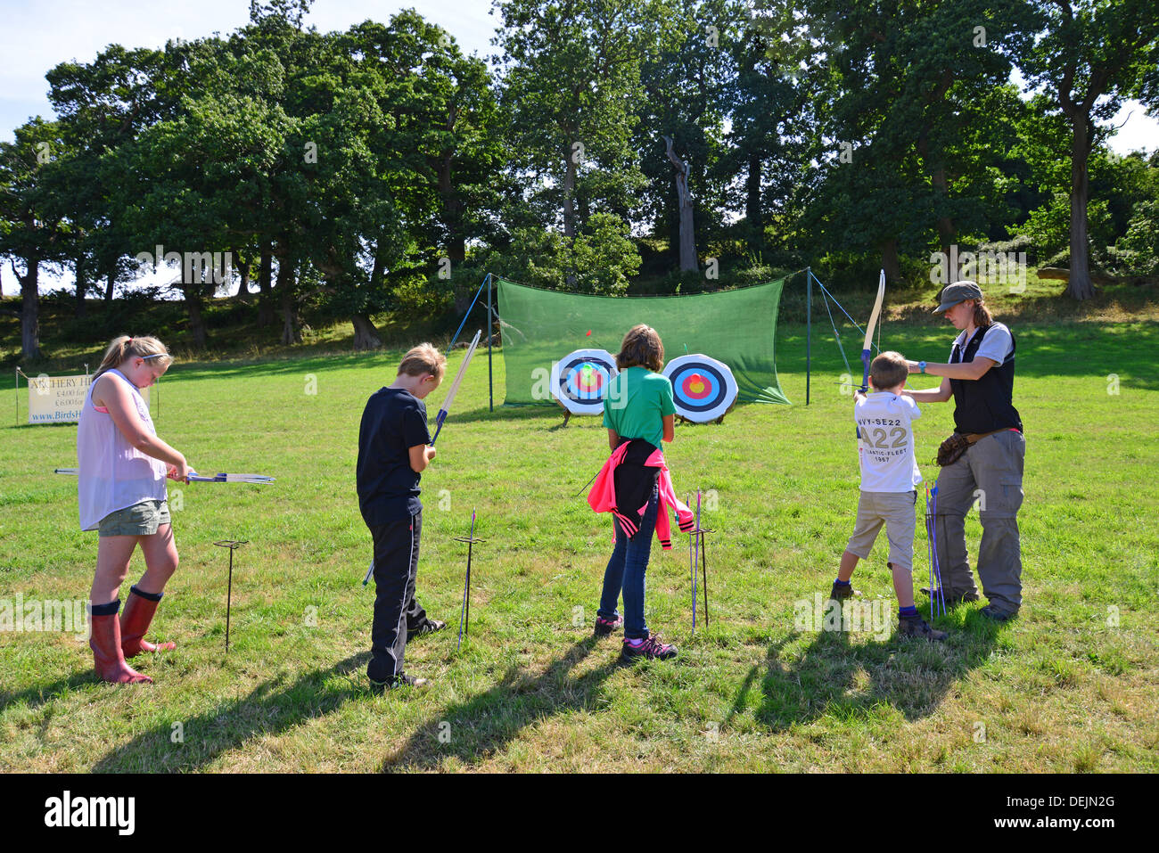 Children trying archery at The Dunster Agricultural Show, Dunster Castle Lawns, Dunster, Somerset, England, United Kingdom Stock Photo