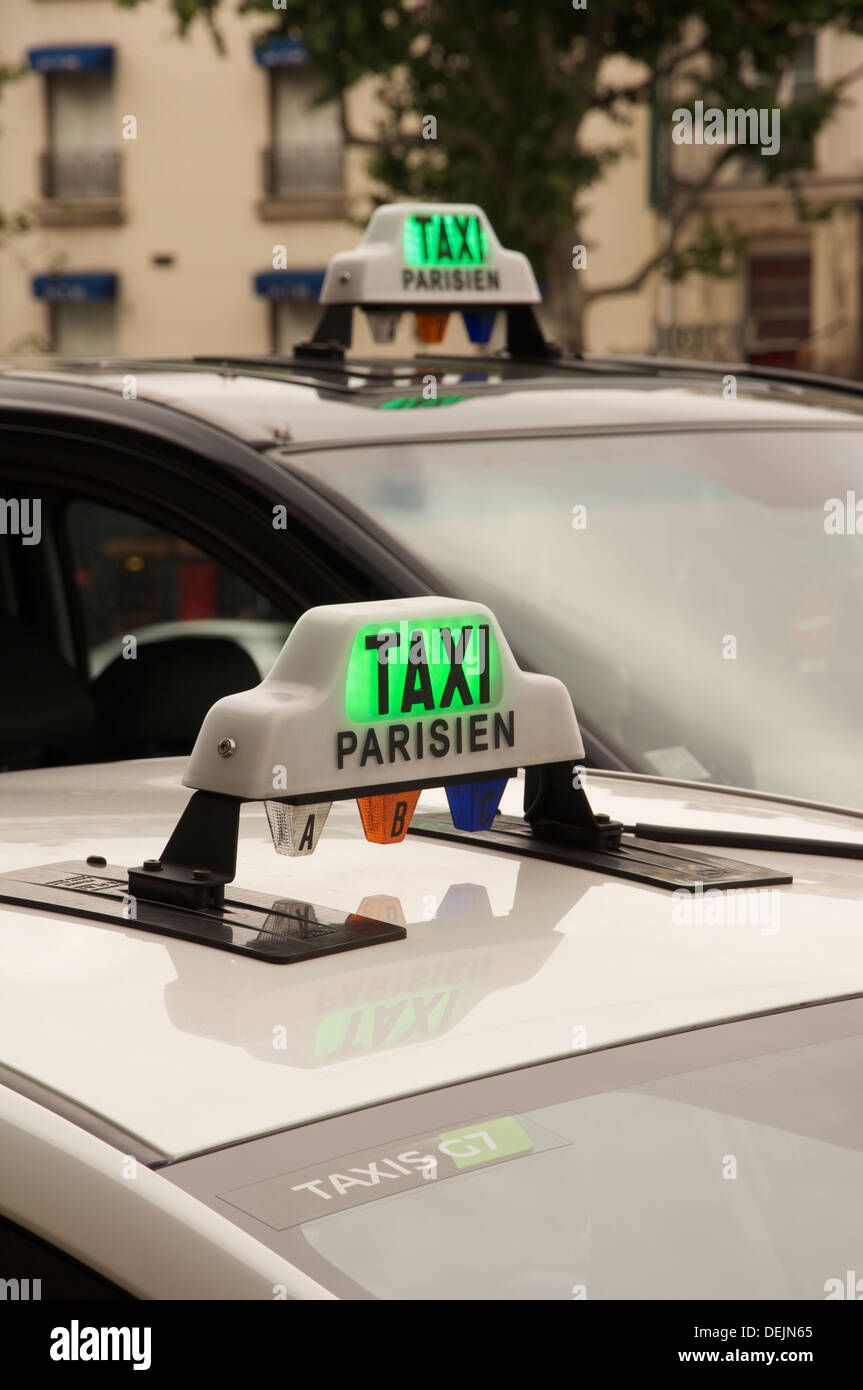 French public transport. The illuminated roof signs of two Parisian taxi cabs, waiting for their next fare. Paris, France. Stock Photo