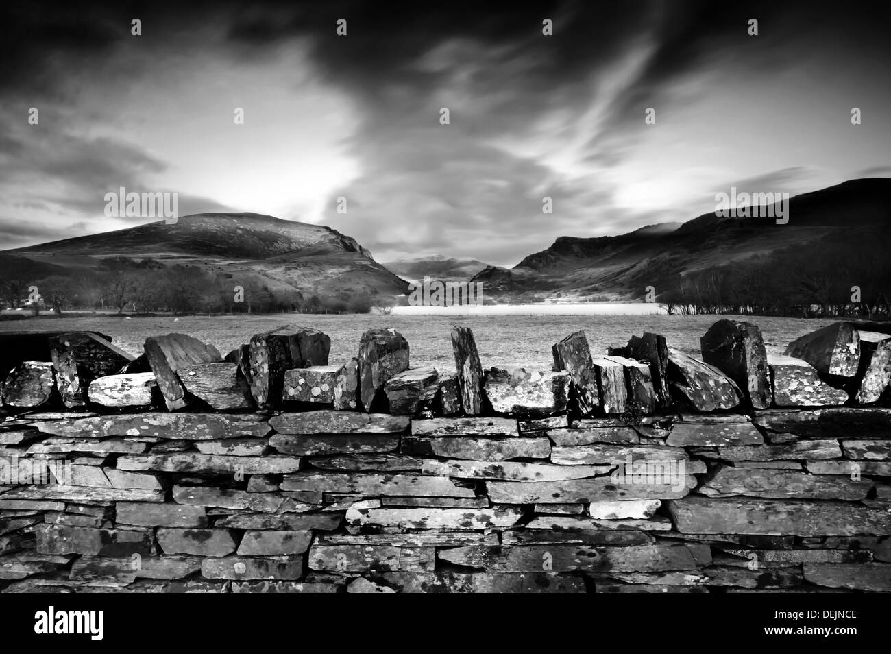 Stone wall and sunset in North Wales, UK, summit of Snowdonia in background Stock Photo