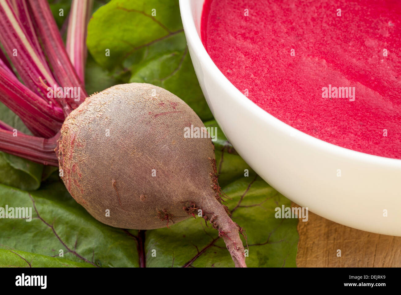 cream soup of red beets with a fresh beet root and leaves Stock Photo