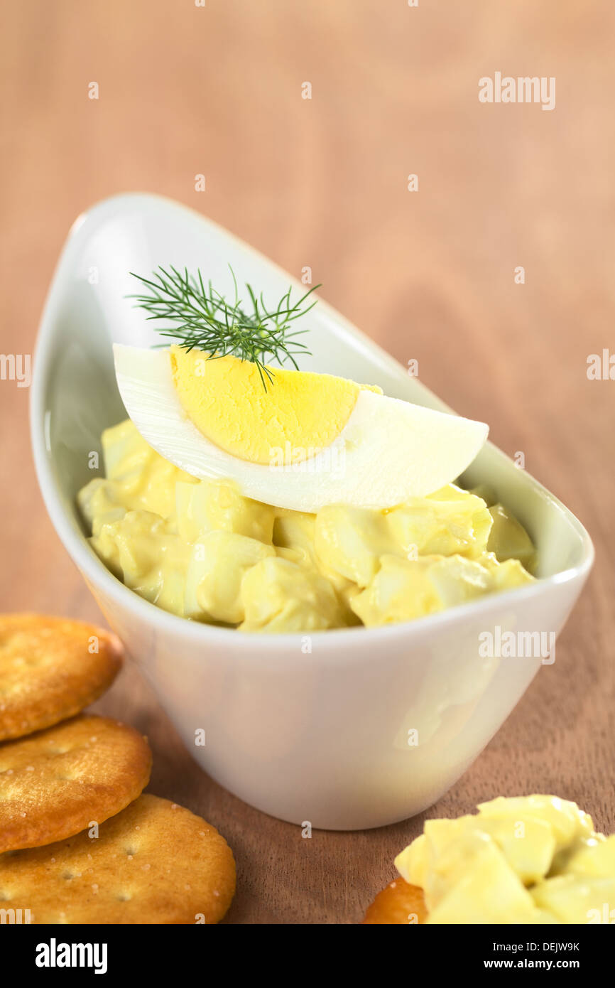 Egg salad garnished with boiled egg and dill served with crackers Stock Photo