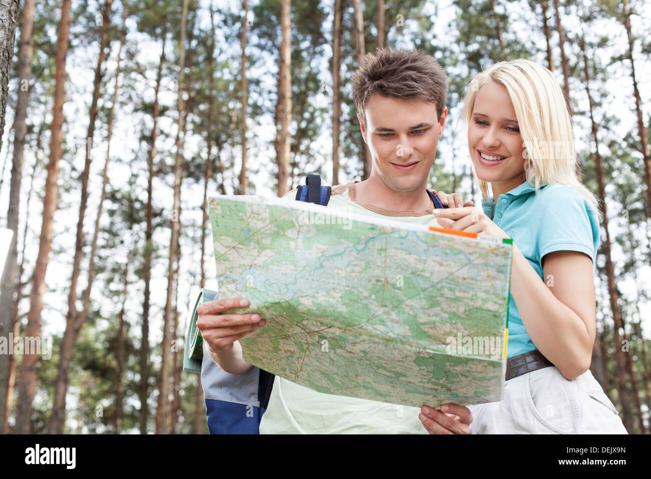 Young hiking couple reading map forest Stock Photo
