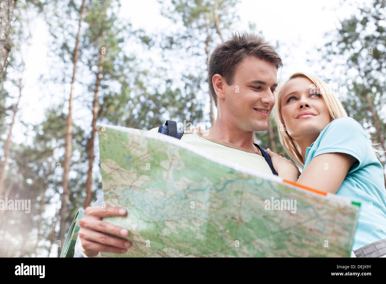 Happy young backpackers holding map forest Stock Photo