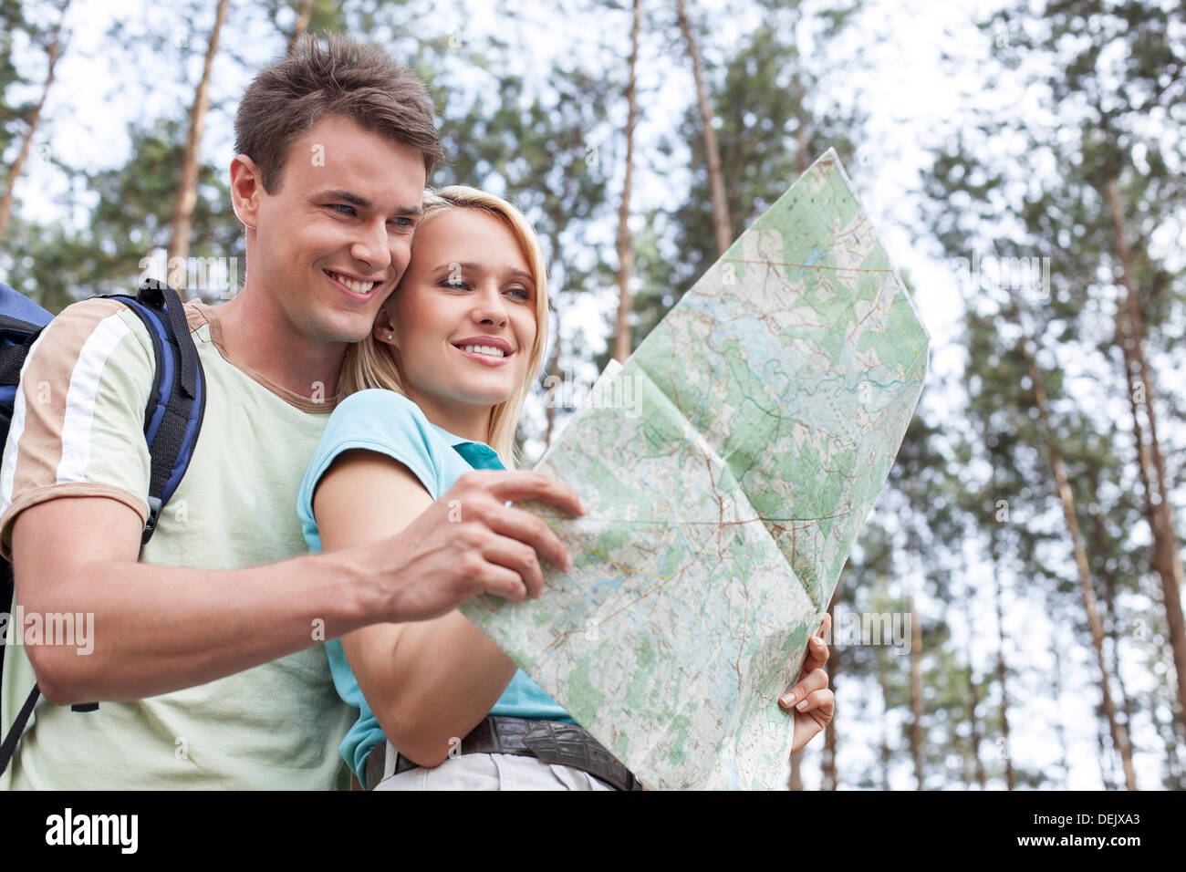 Happy young backpackers reading map forest Stock Photo