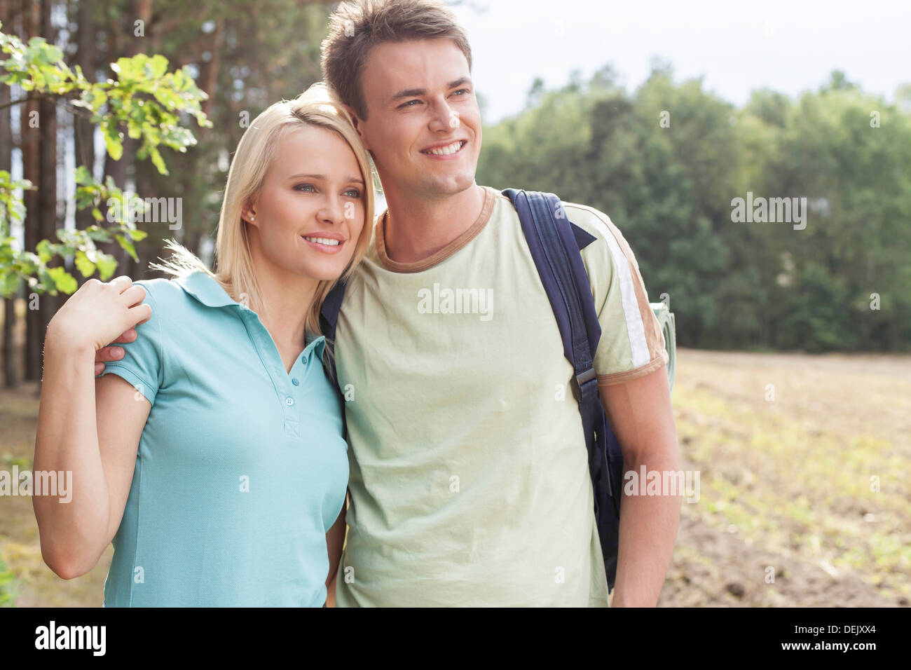Thoughtful young couple smiling while hiking forest Stock Photo