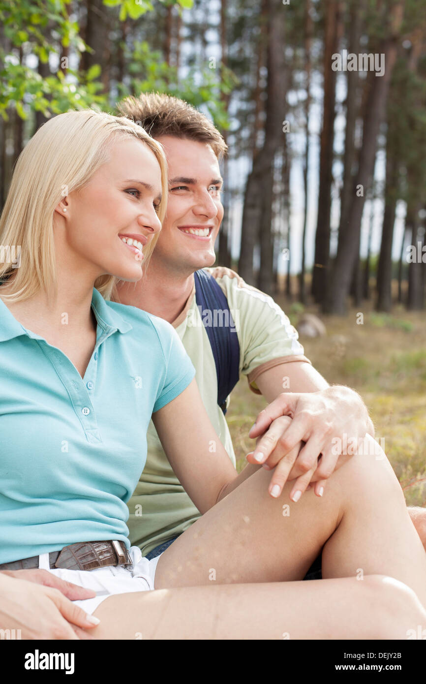 Thoughtful hiking couple looking away while relaxing forest Stock Photo