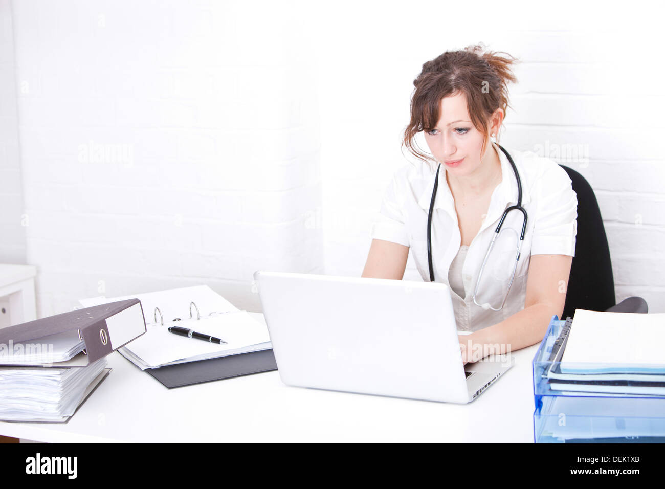 Young female doctor using laptop desk clinic Stock Photo