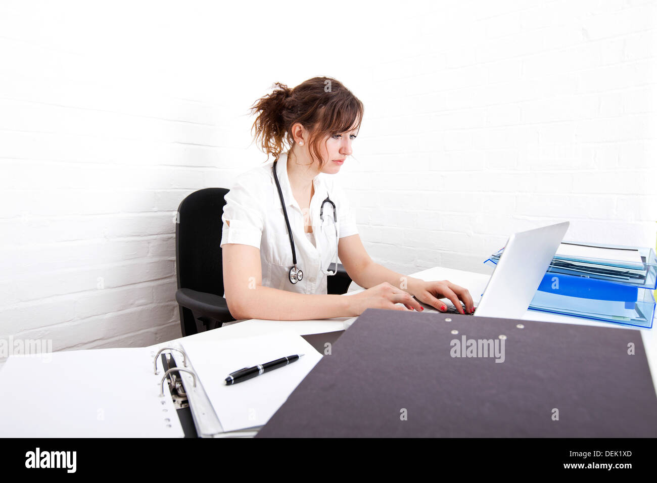 Young female doctor using laptop desk clinic Stock Photo