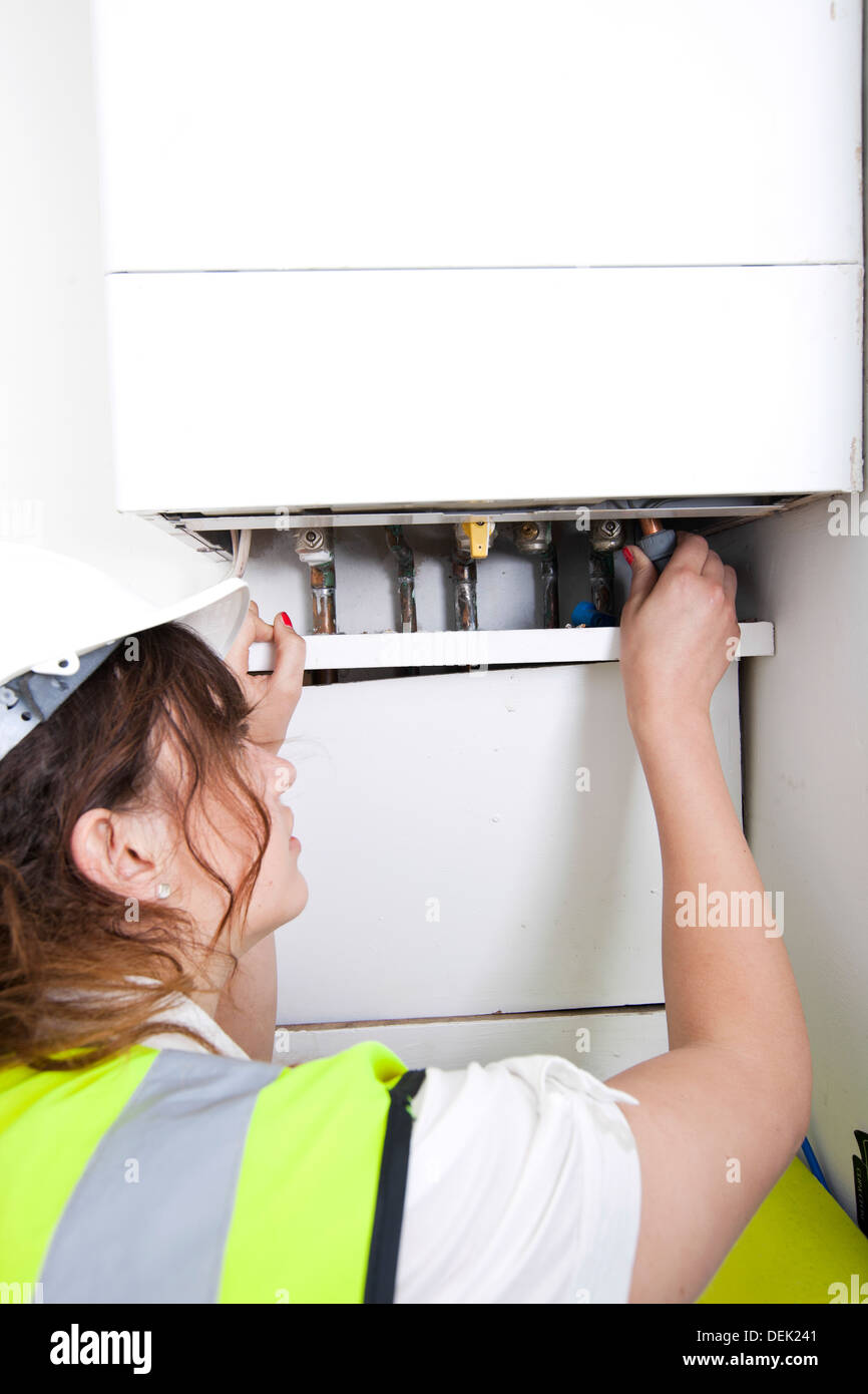 Female plumber servicing central heating boiler Stock Photo