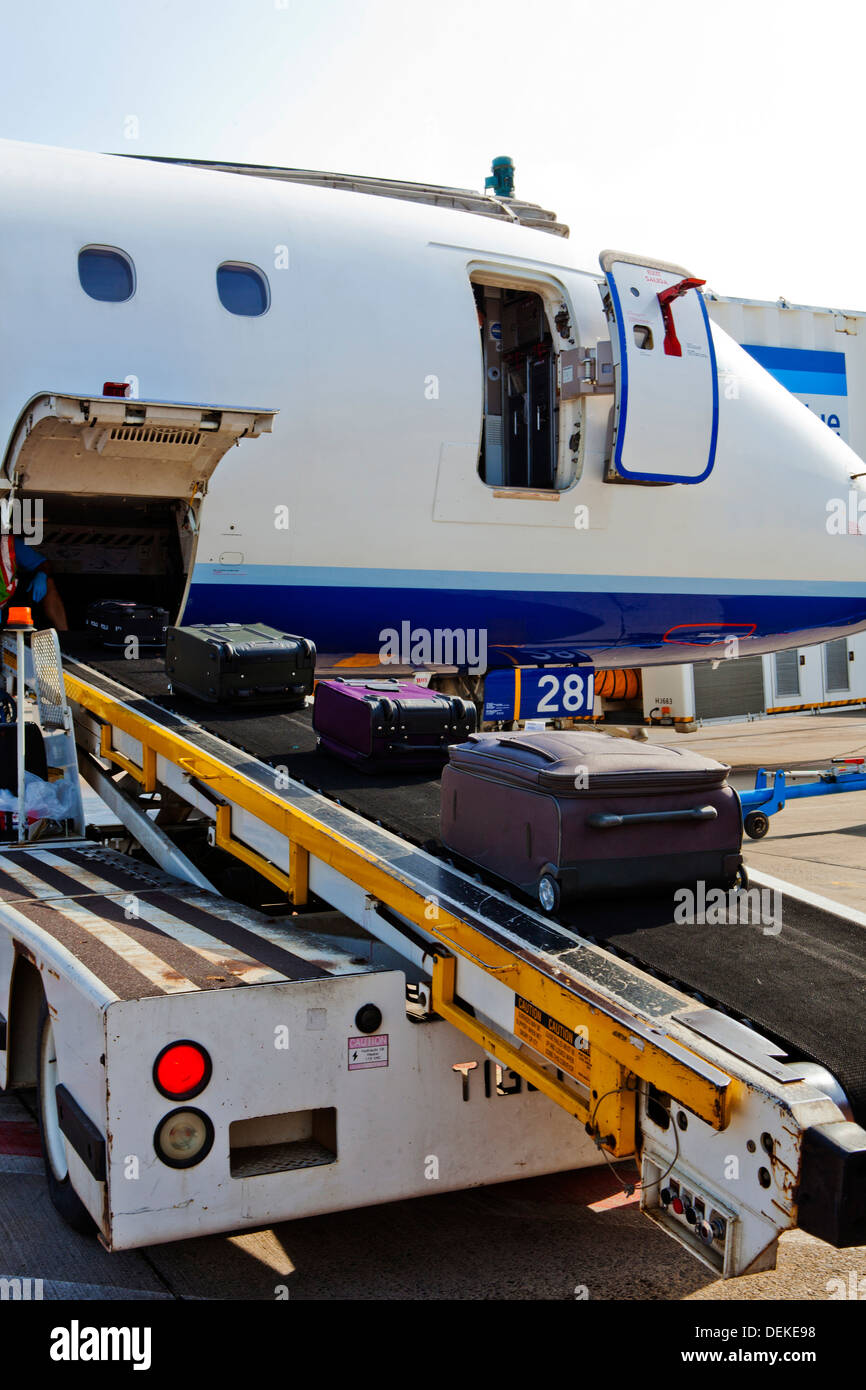 Luggage on conveyor belt by airplane cargo hold Stock Photo Alamy