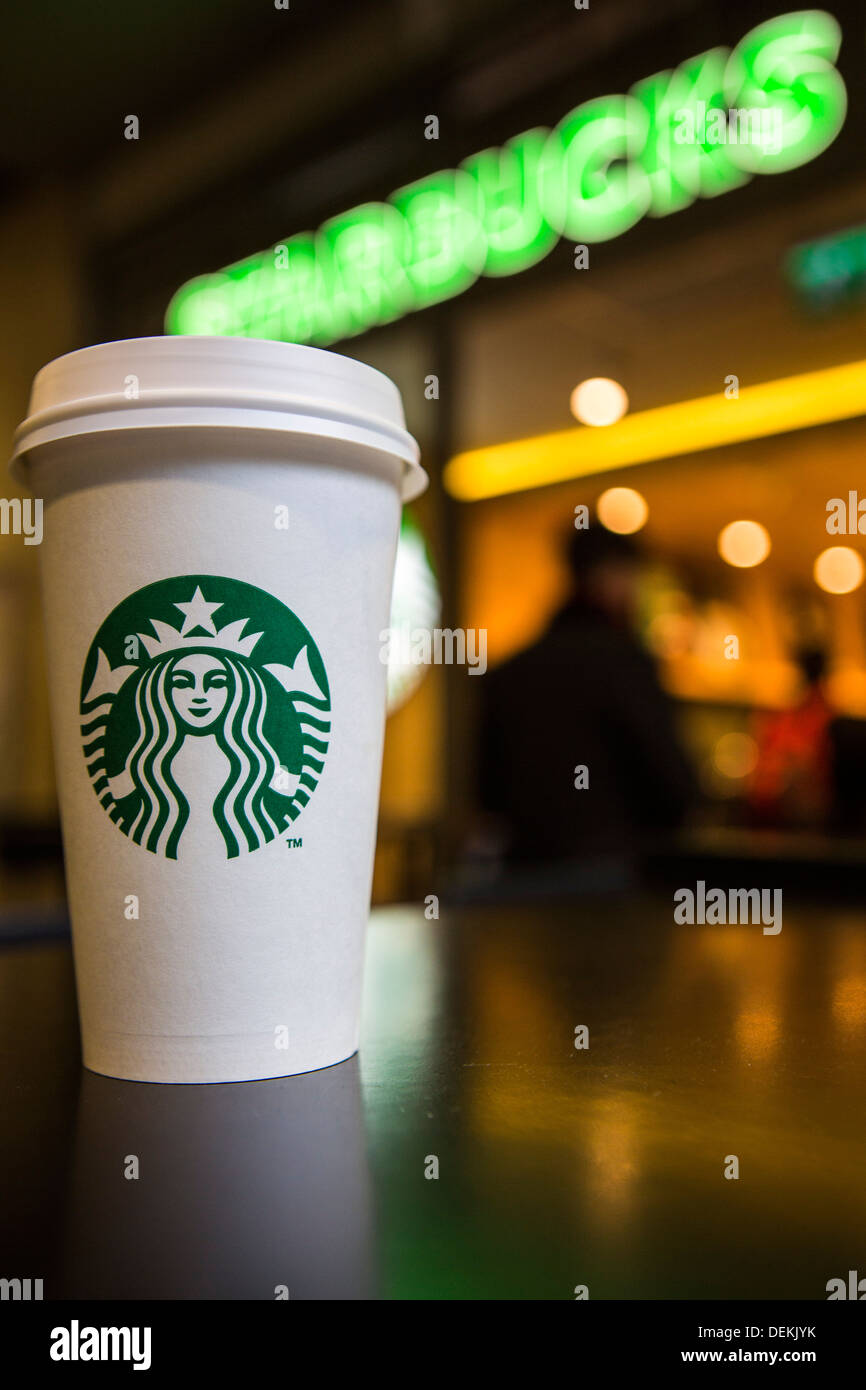 A Starbucks coffee cup sitting on a table outside Starbucks coffee shop, Canary Wharf. London, UK. Stock Photo