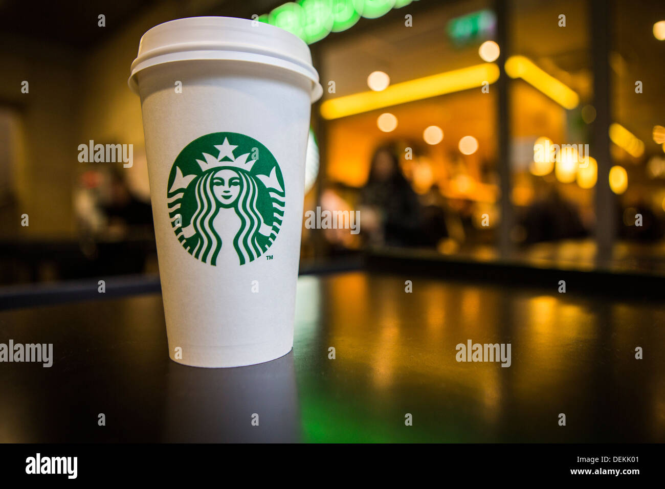 A Starbucks coffee cup sitting on a table outside Starbucks coffee shop, Canary Wharf. London, UK. Stock Photo
