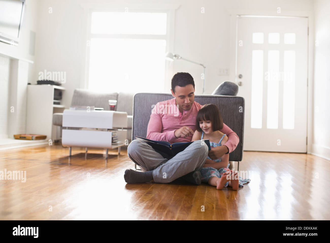 Father and daughter using digital tablet in living room Stock Photo