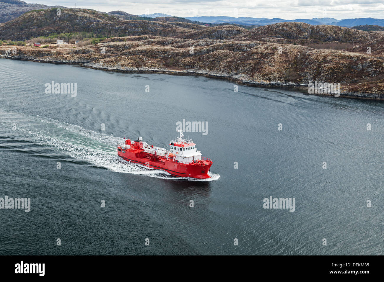 Small Norwegian red oil products tanker sails in the fjord Stock Photo