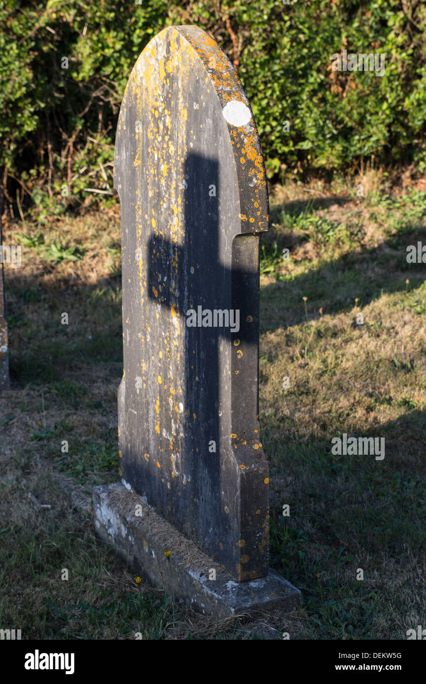 A cross shadow on a gravestone.The Blessed Virgin Mary Church, a fifteenth century church in the village of Donyatt in Somerset. Stock Photo