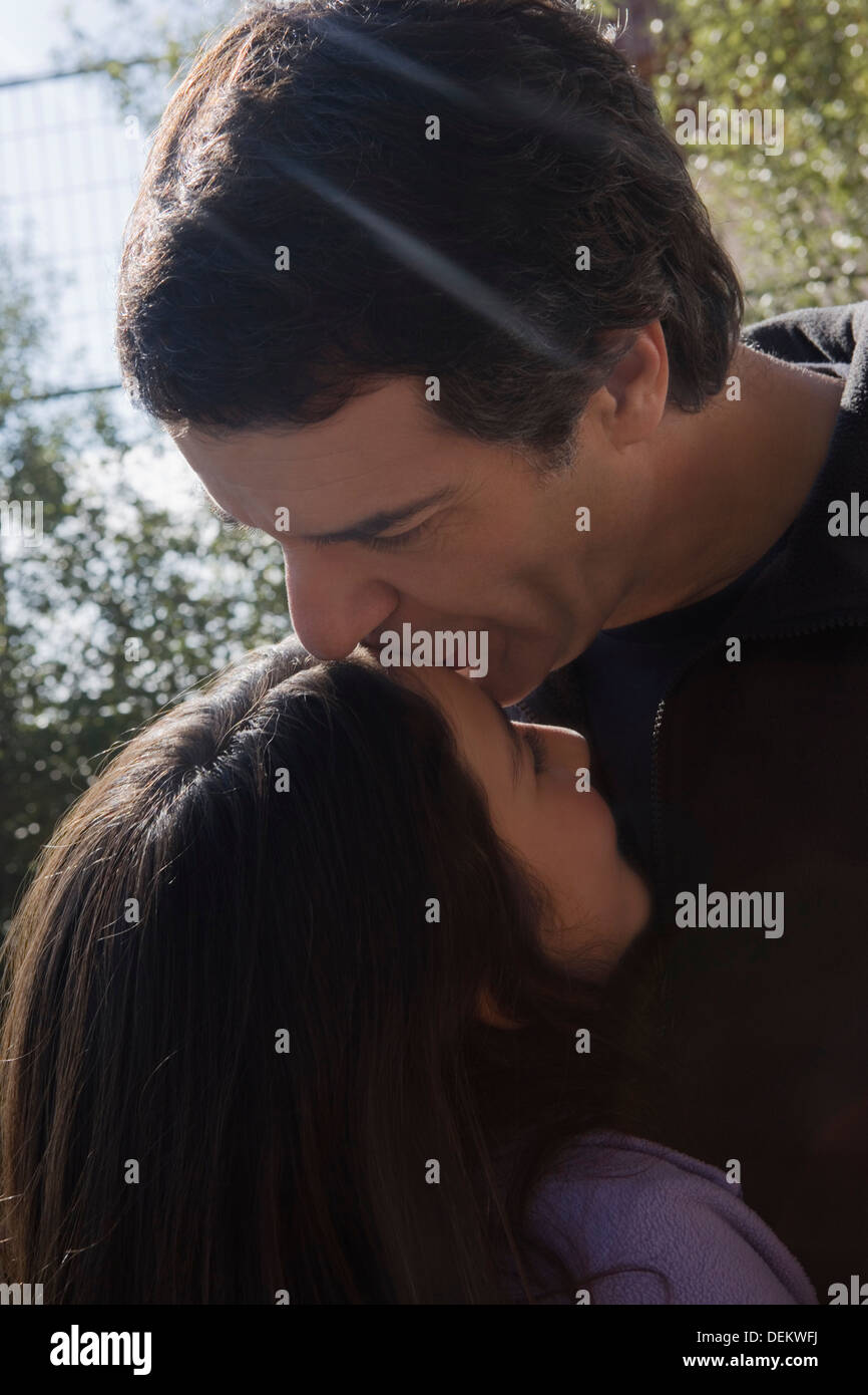 Hispanic man kissing daughter's forehead Stock Photo
