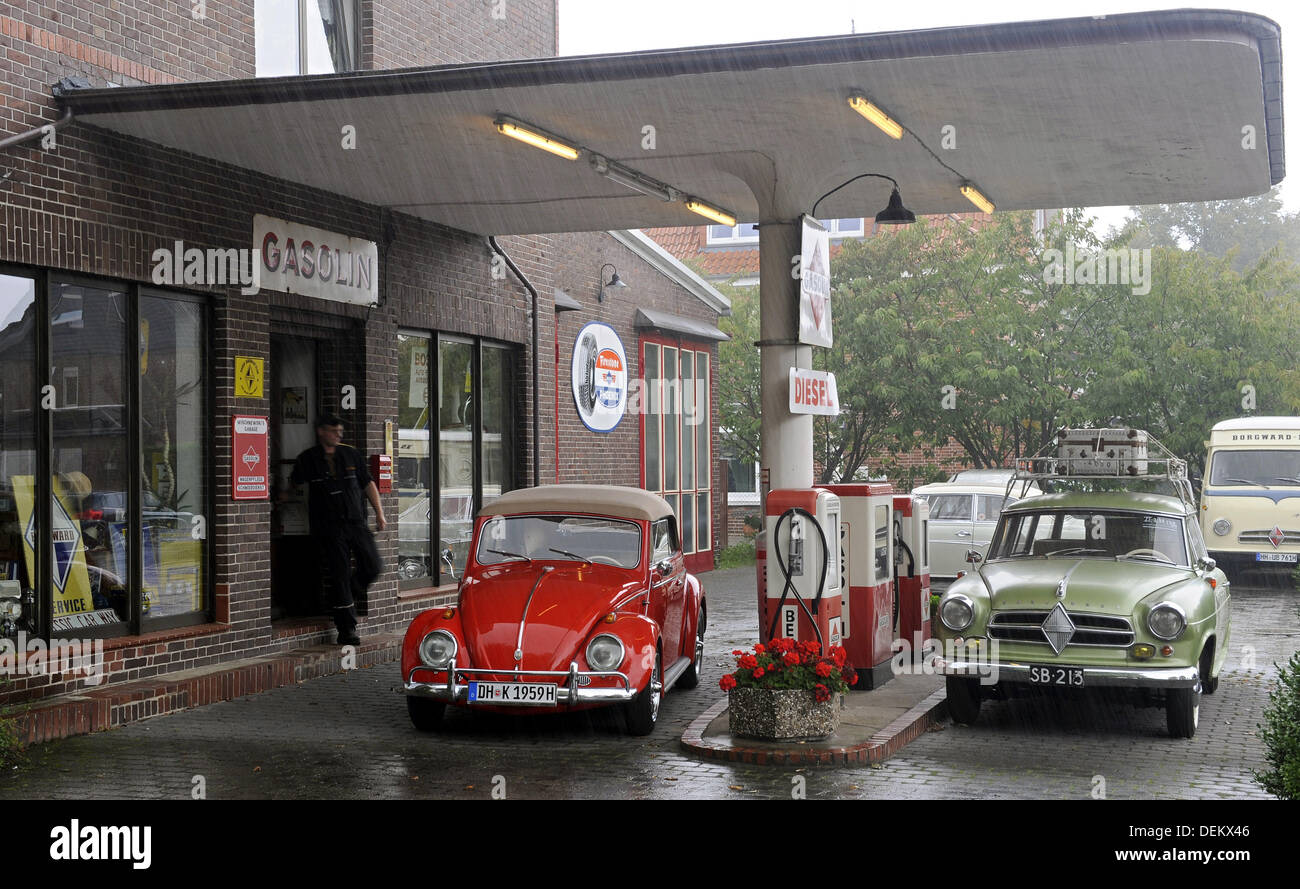 Oldtimer specialist Volker Wischnewski walks through the rain at his historic gas station in Bruchhausen-Vilsen, Germany, 20 September 2013. The station operator specializes in the repair and restoration of Borgward group (R) vehichles. The VW bug is also being repaired here. Photo: INGO WAGNER Stock Photo