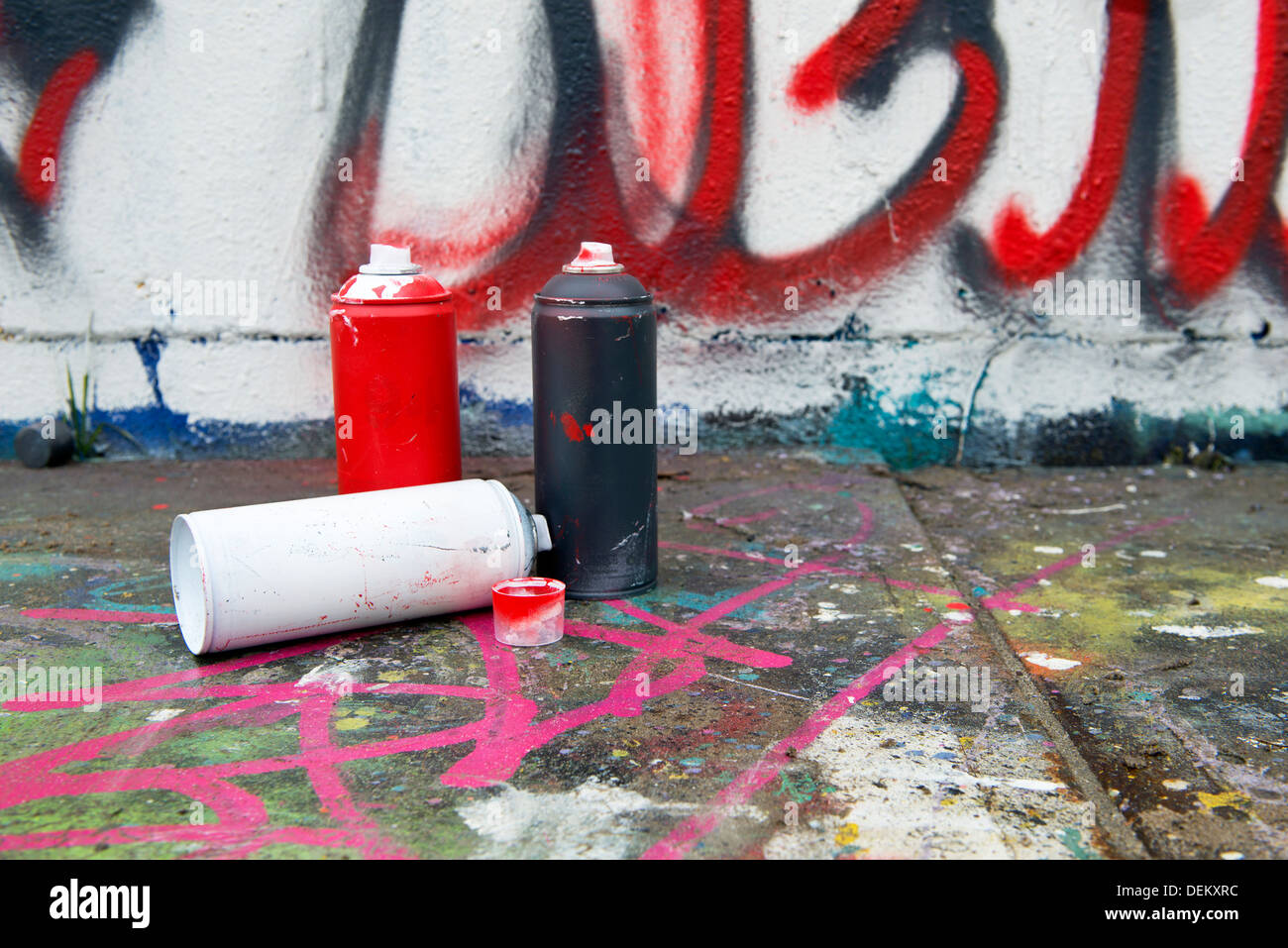 Spray paint cans by graffiti wall Stock Photo