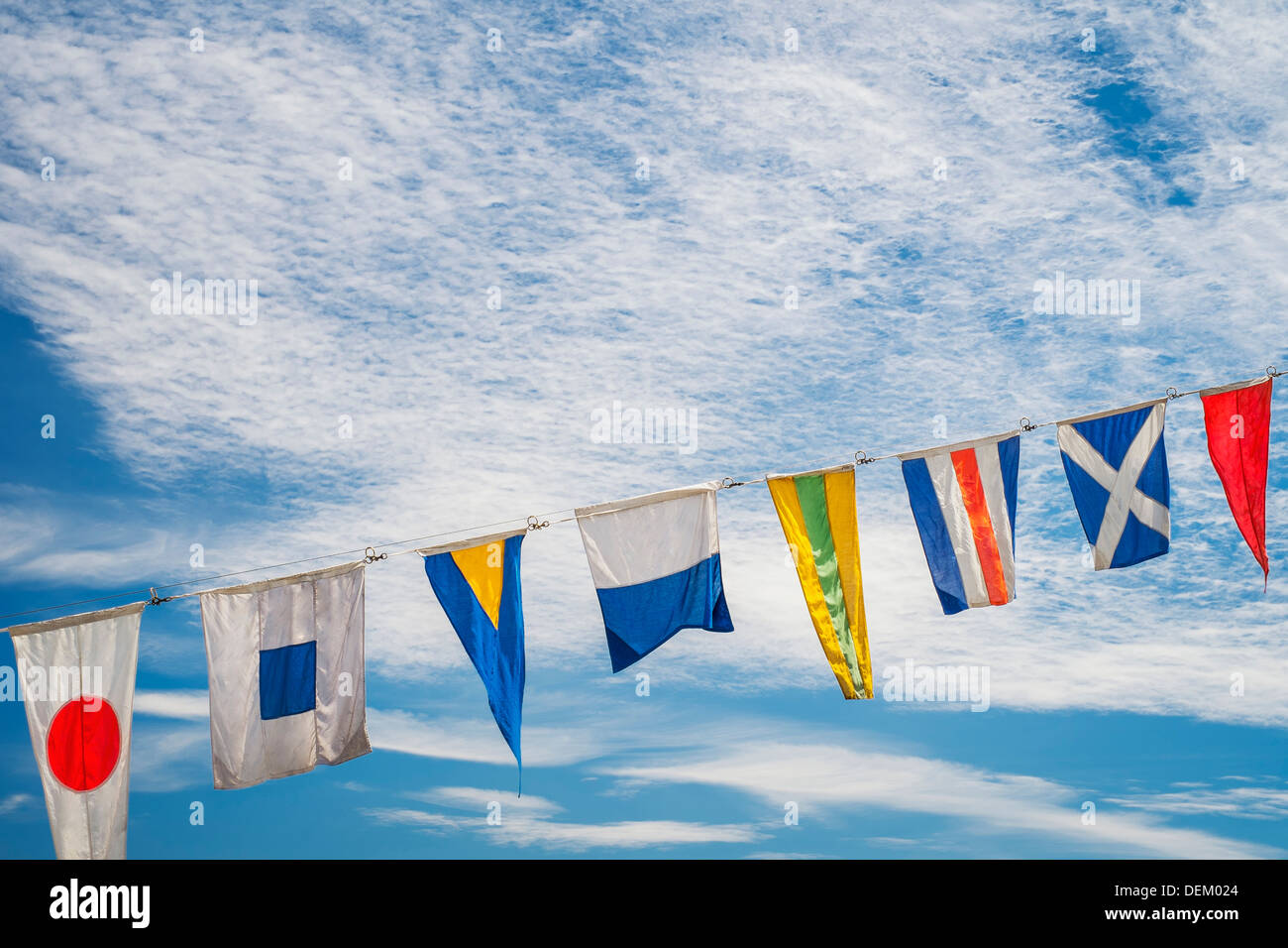 Flags flying against blue sky Stock Photo