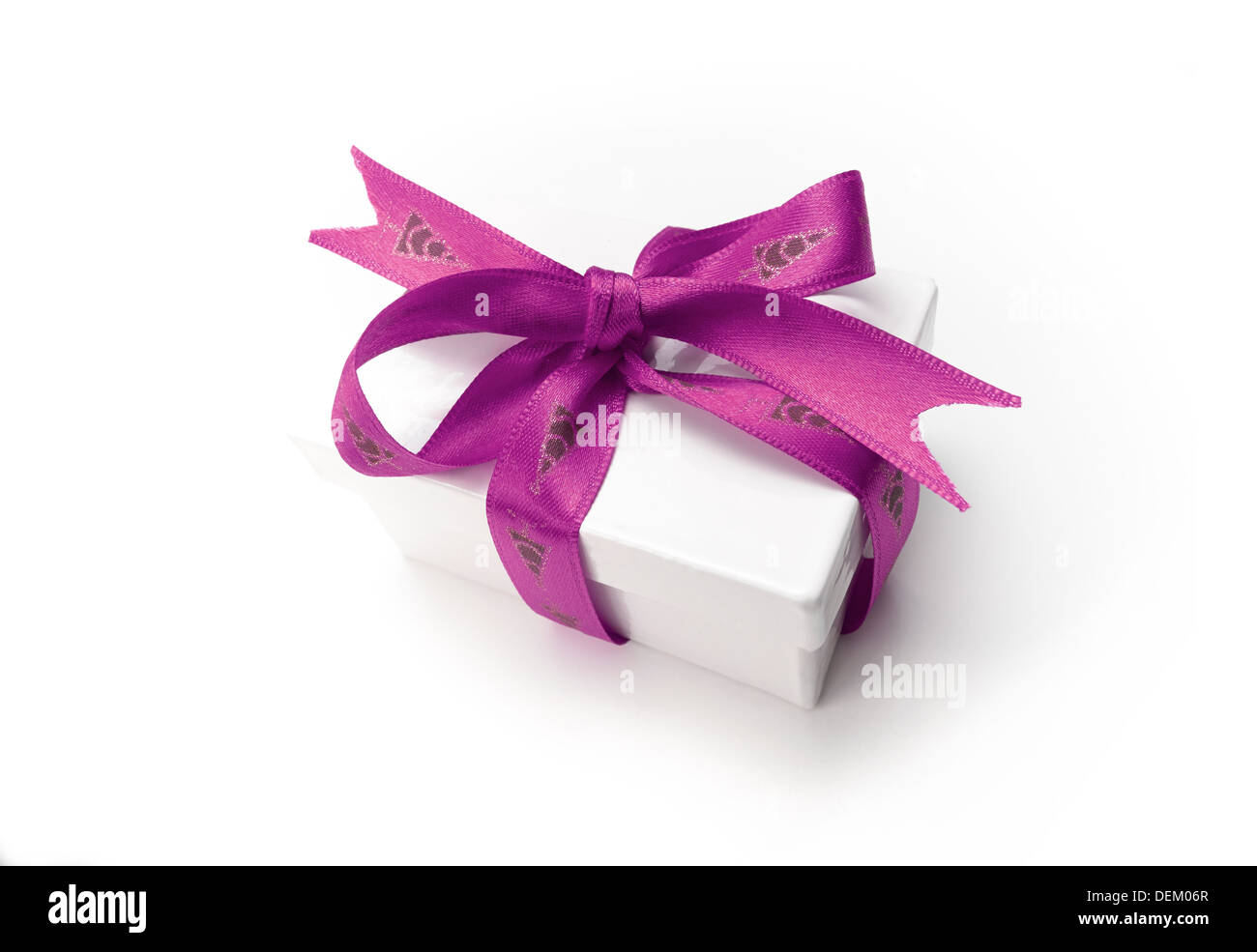 A wrapped Christmas present with a colourful pink ribbon and bow on a white background. Stock Photo