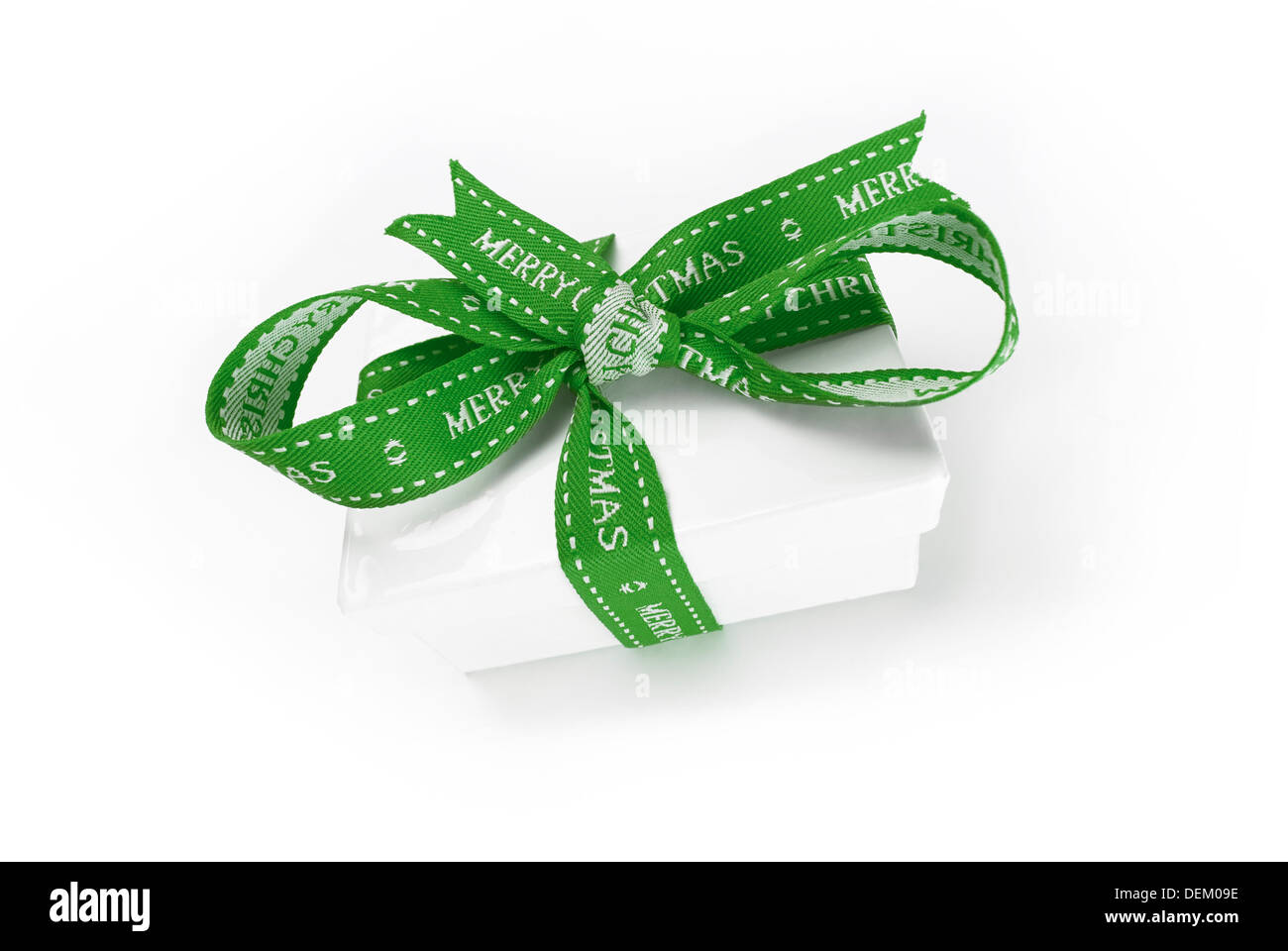 A wrapped Christmas present with a colourful green ribbon and bow on a white background. Stock Photo