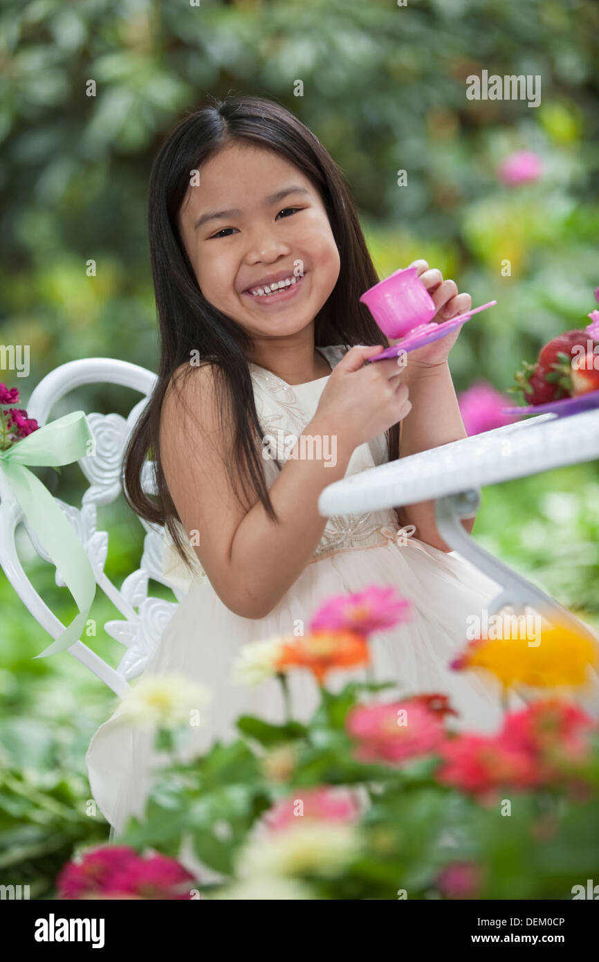 Mixed race girl having tea party in backyard Stock Photo - Alamy