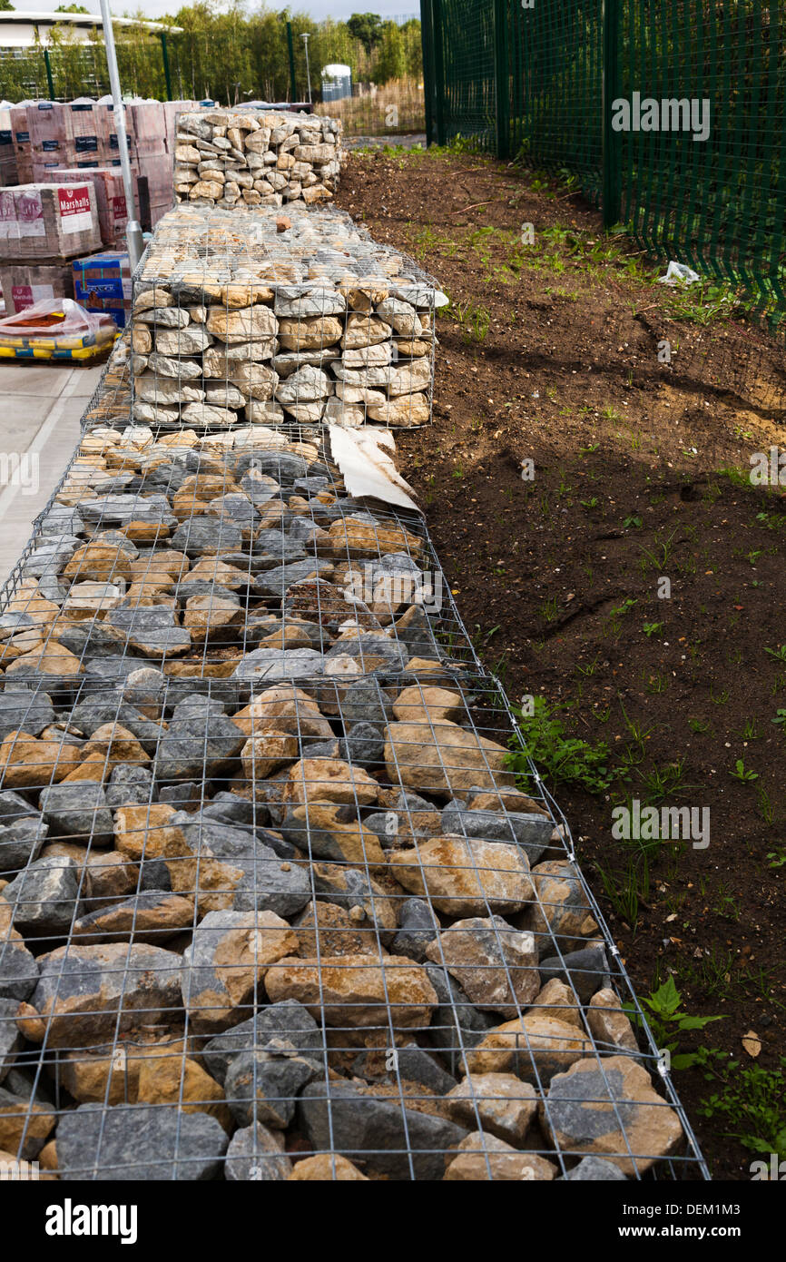 earth retaining wall of gabion mesh caged stones Stock Photo