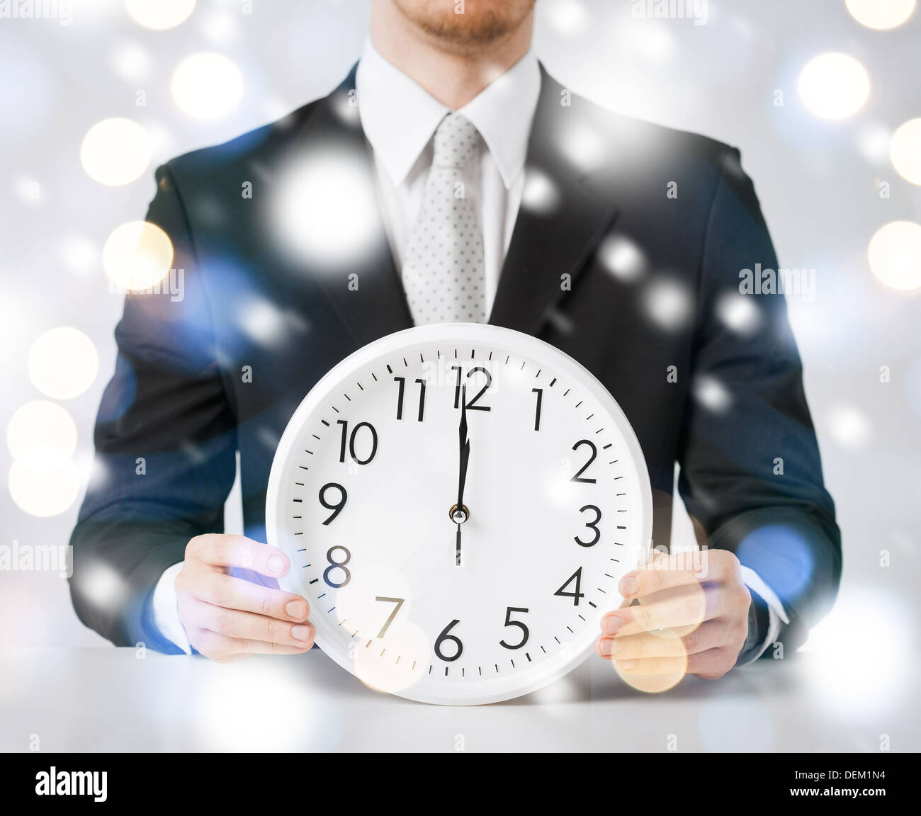 man holding wall clock showing 12 Stock Photo Alamy