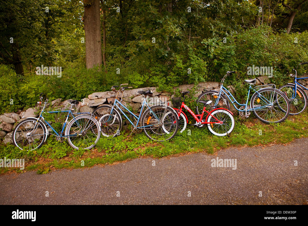 Row of Bicycles Leaning Against Rock Wall Stock Photo