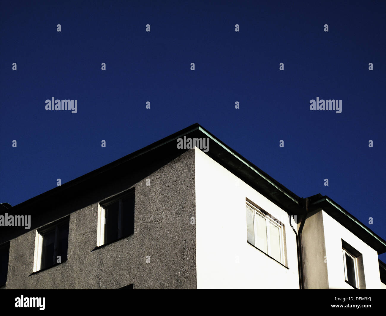 Top Floor of Apartment Building Against Blue Sky, Low Angle View Stock Photo