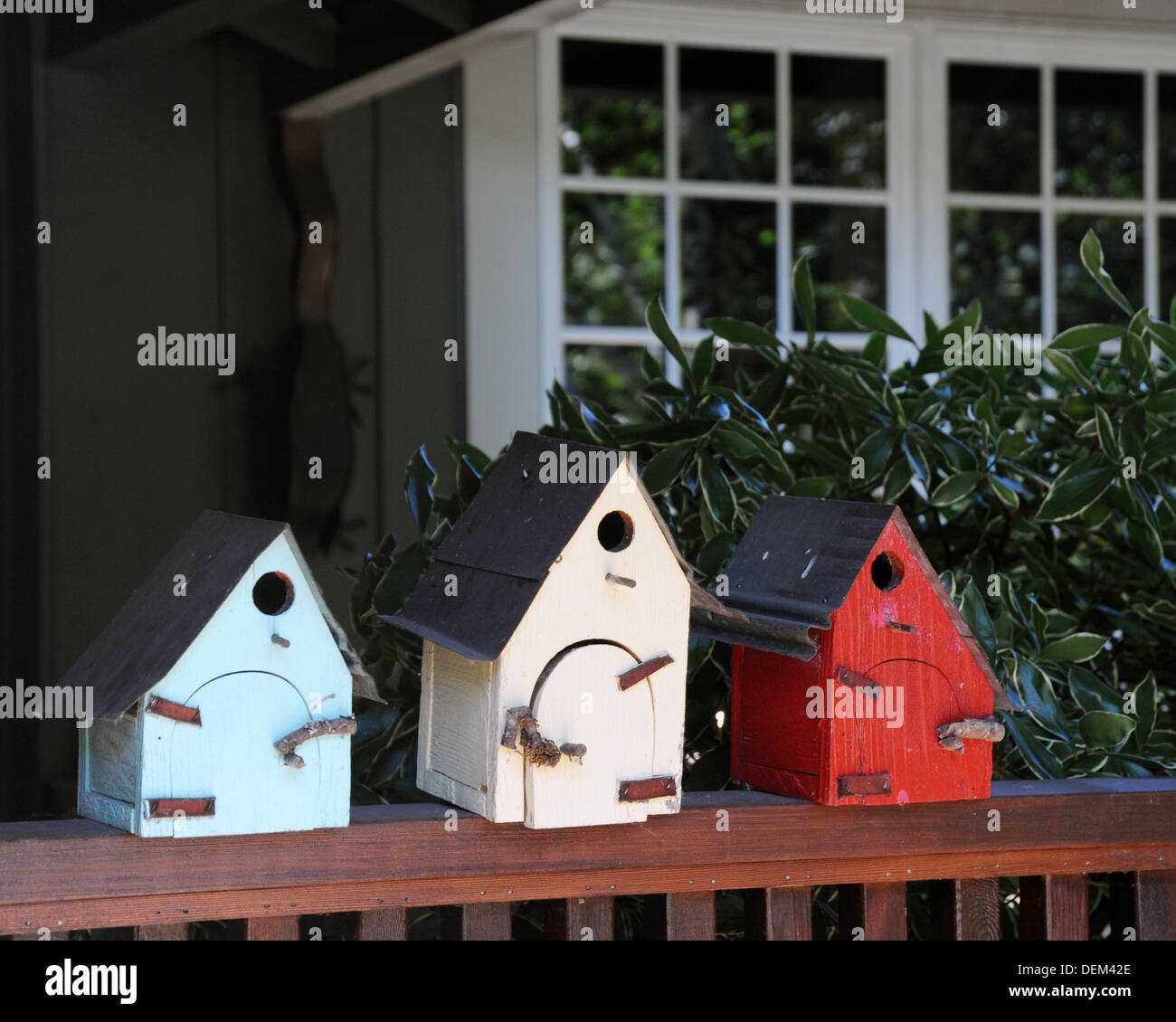 Three bird houses, blue, white and red, in front of home Lake Oswego Oregon, Stock Photo
