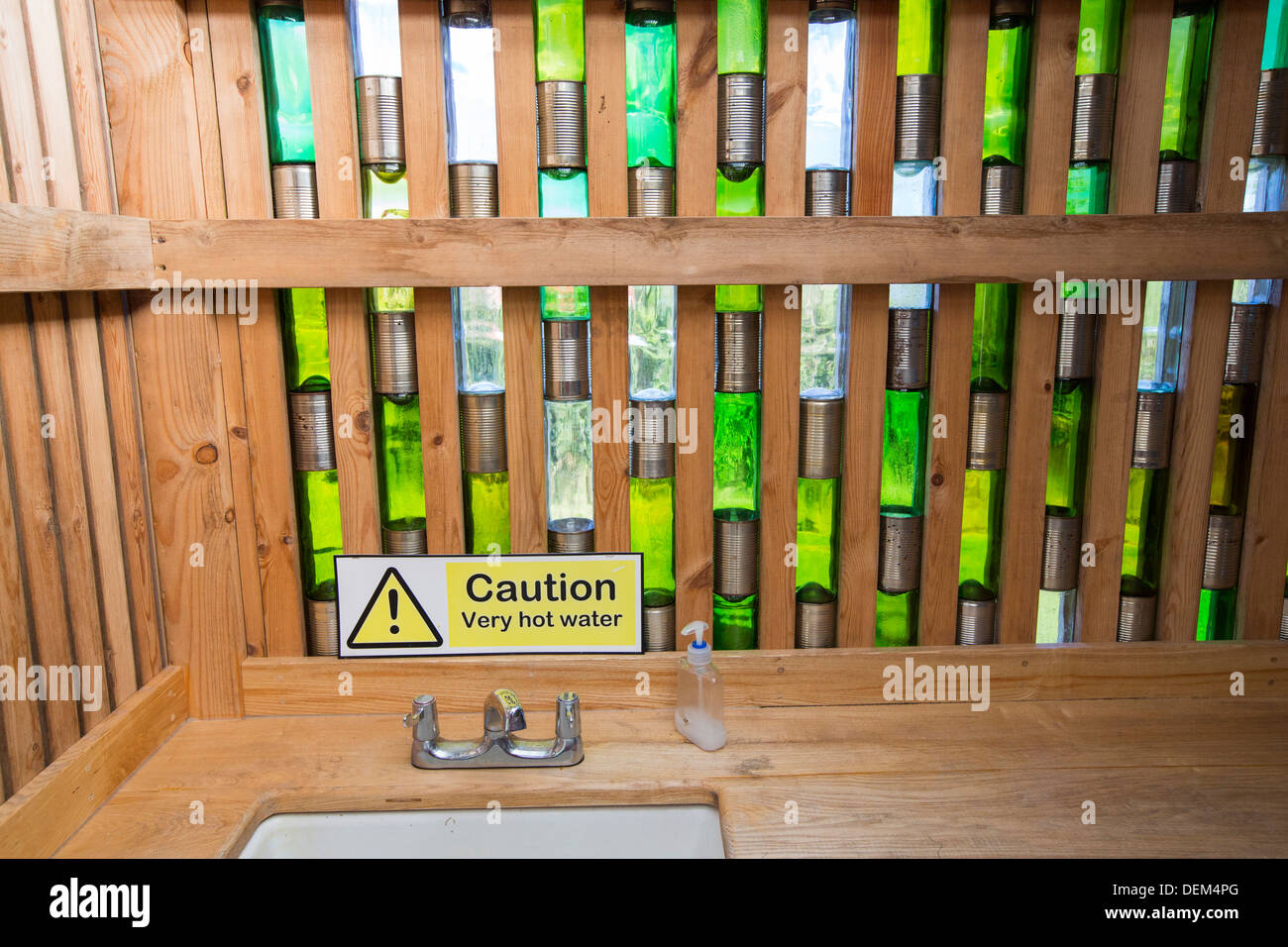 A washing block contructed of timber, glass bottles and old tin cans at