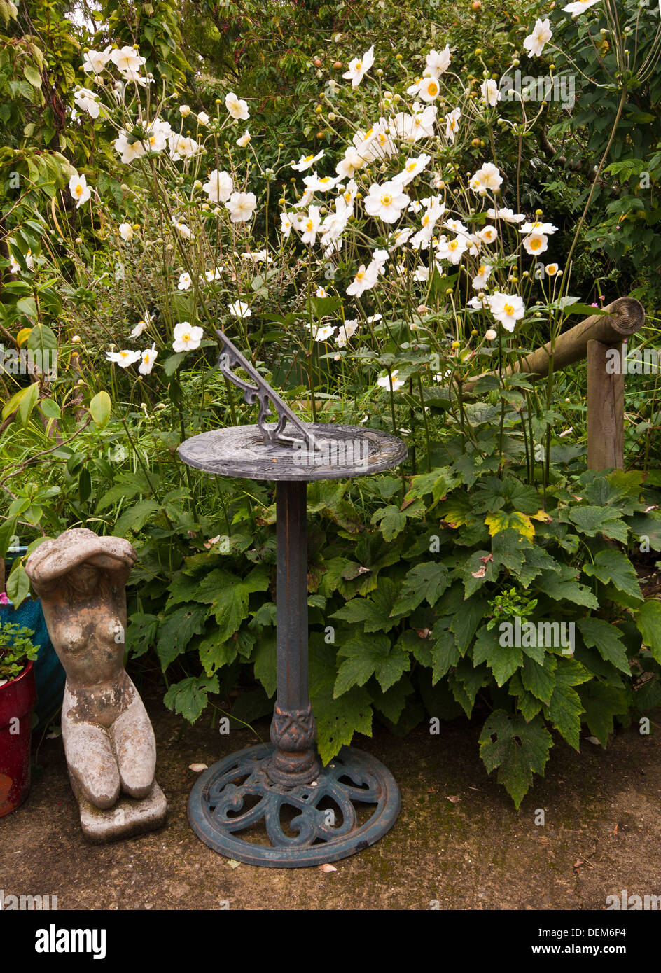Sundial In a Cottage Garden With White Japanese Anemones Stock Photo