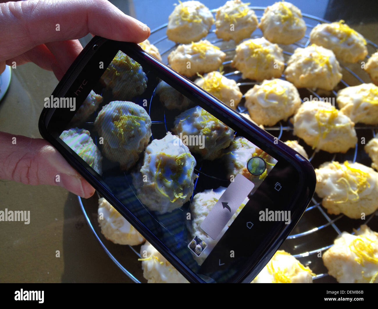 Person taking pictures of Cookies with digital mobile & camera Stock Photo
