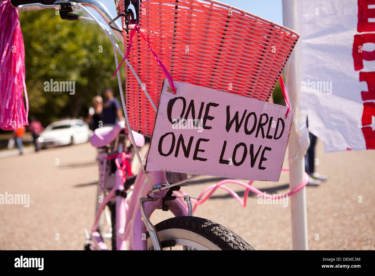 One World One Love sign on pink bicycle Stock Photo