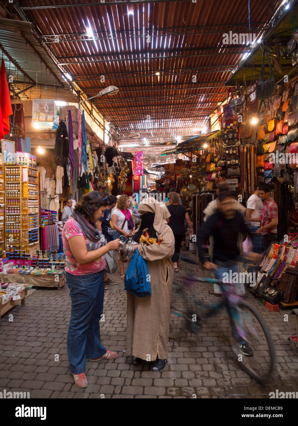 Tourist haggling with female seller in the streets of the Marrakech souk, Morocco Stock Photo