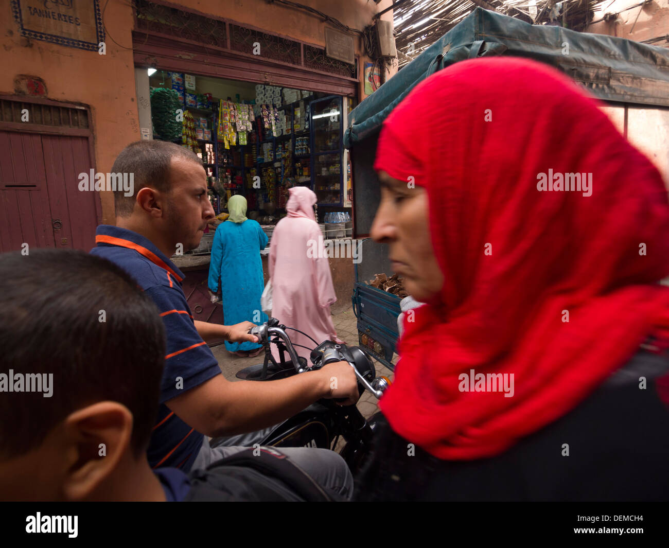 Arab woman wearing a red hijab in the crowded streets of Marrakesh, Morocco Stock Photo