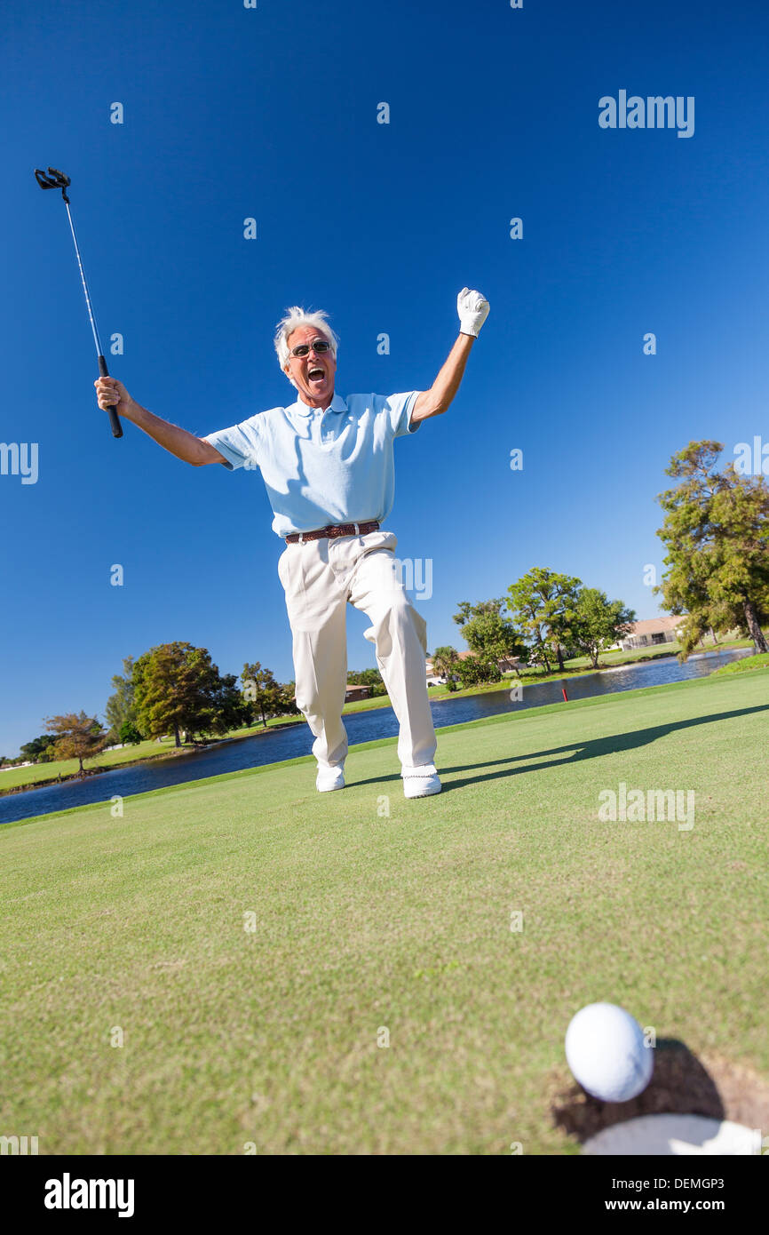 Senior man male golfer celebrating successful put on the green of a