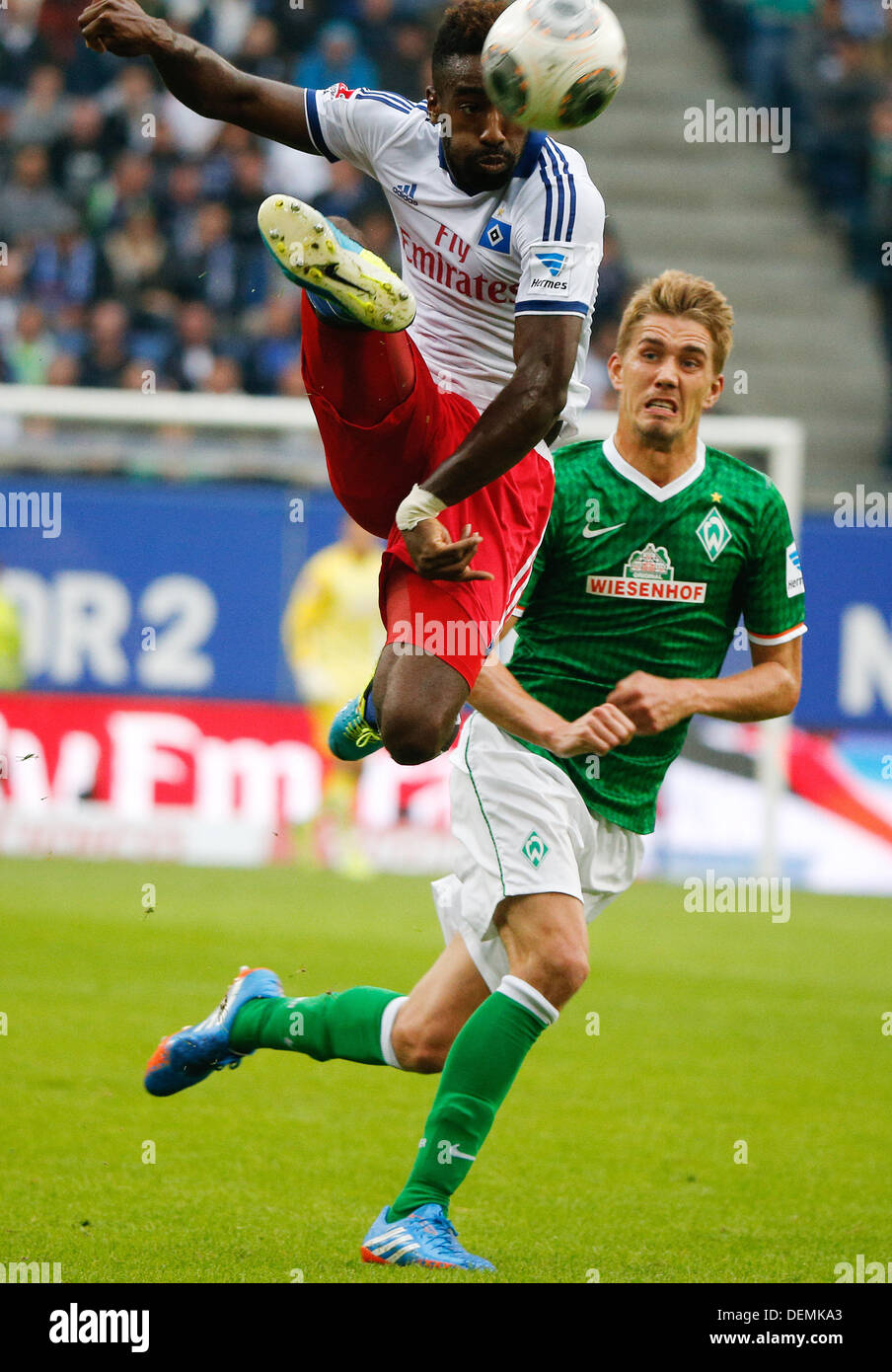 Hamburg, Germany. 21st Sep, 2013. Bremen's Nils Petersen (R) vies for the ball with Hamburg's Johan Djourou during the Bundesliga soccer match between Hamburger SV and Werder Bremen at Imtech-Arena in Hamburg, Germany, 21 September 2013. Photo: AXEL HEIMKEN (ATTENTION: Due to the accreditation guidelines, the DFL only permits the publication and utilisation of up to 15 pictures per match on the internet and in online media during the match.)/dpa/Alamy Live News Stock Photo